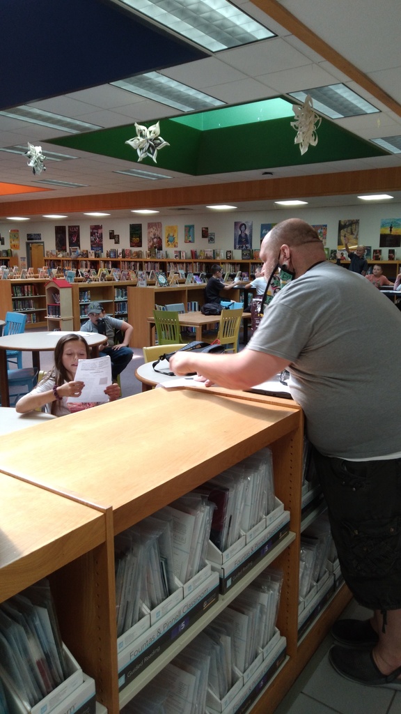 A+ Enrichment Leader, Mr. Adam, reads with a student promoting literacy skills during academic time!